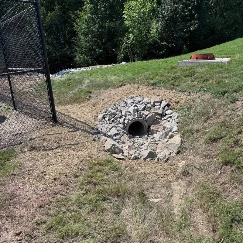 Close-up of a finished stone rip-rap dissipator at a culvert outlet