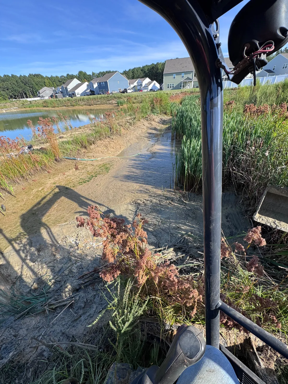 Excavator grading a stormwater channel at Nathans Ridge Pond